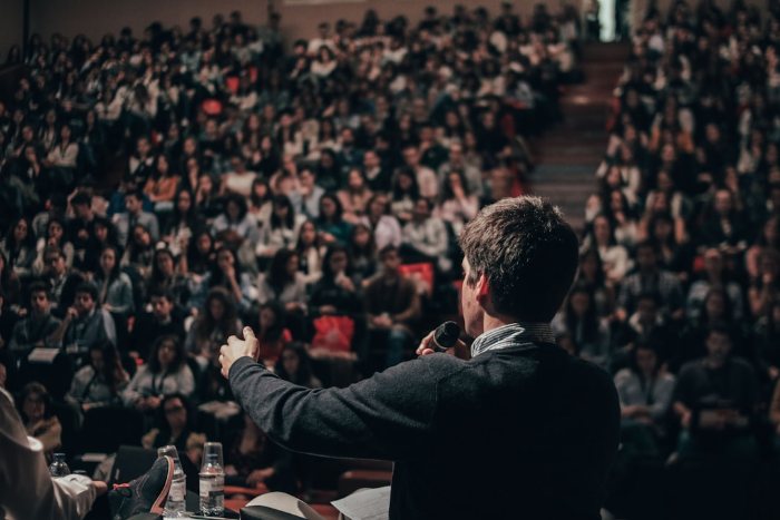 WHO-Sypmosium: Mann spricht vor großen Publikum und hält einen Vortrag